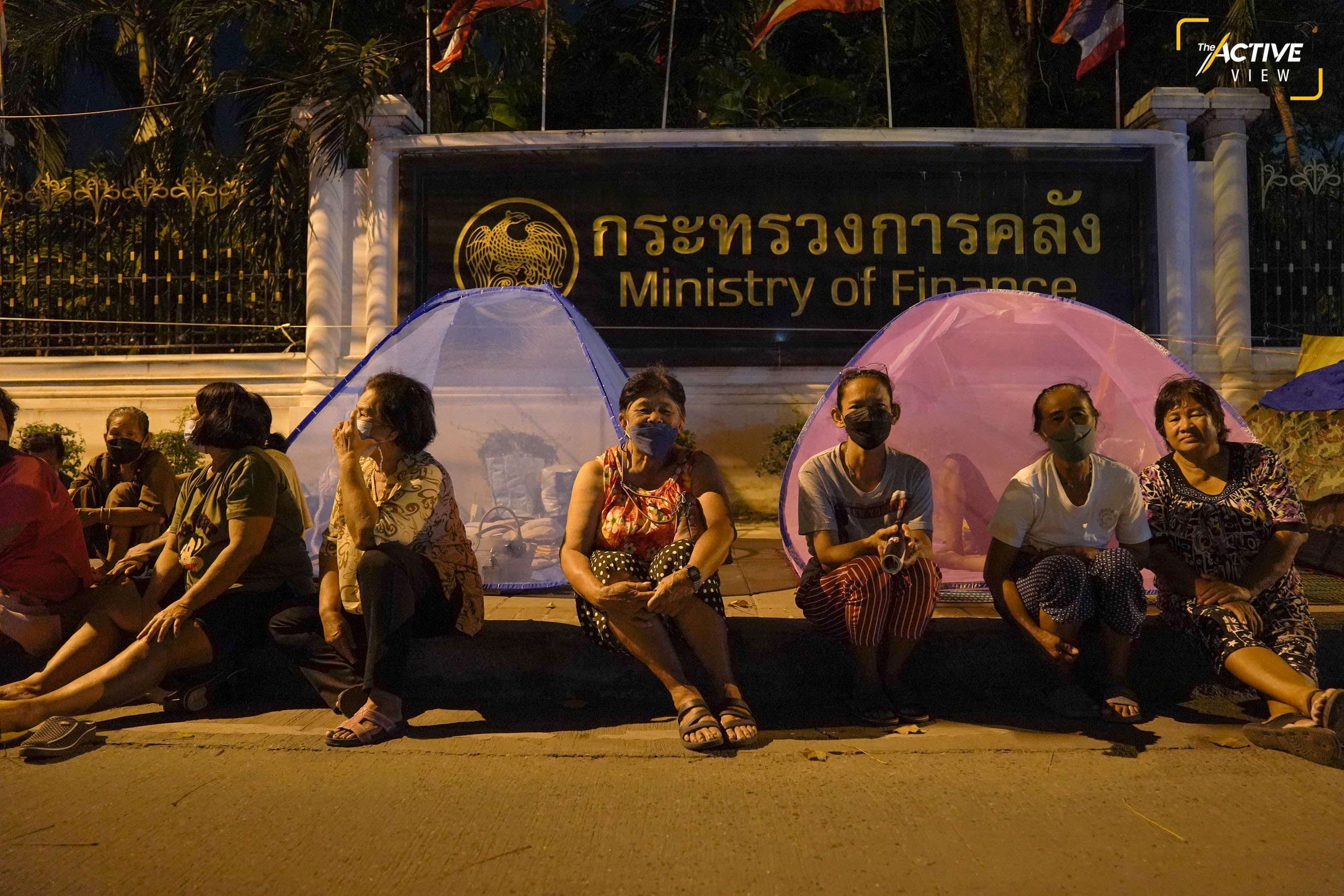 ไม่ห่างจากการชุมนุมของกลุ่มพีมูฟมากนัก จากถนนพิษณุโลก เราเดินทางไปต่อที่ กระทรวงการคลัง บนถนนเส้นพระราม 6
.
ชาวนาที่รวมตัวกันในชื่อ “เครือข่ายหนี้สินชาวนาแห่งประเทศไทย” ก็ยังคงเรียกร้องการแก้ไขปัญหานานนับสัปดาห์แล้วเช่นกัน
.
พวกเขาเรียกร้อง ให้ ครม. มีมติช่วยจัดการหนี้สินของเกษตรกร ผ่านกองทุนฟื้นฟูและพัฒนาเกษตรกร